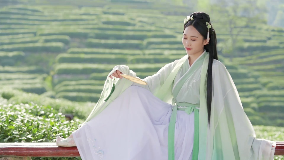 A beautiful woman in ancient costumes with bamboo fans in Hanfu