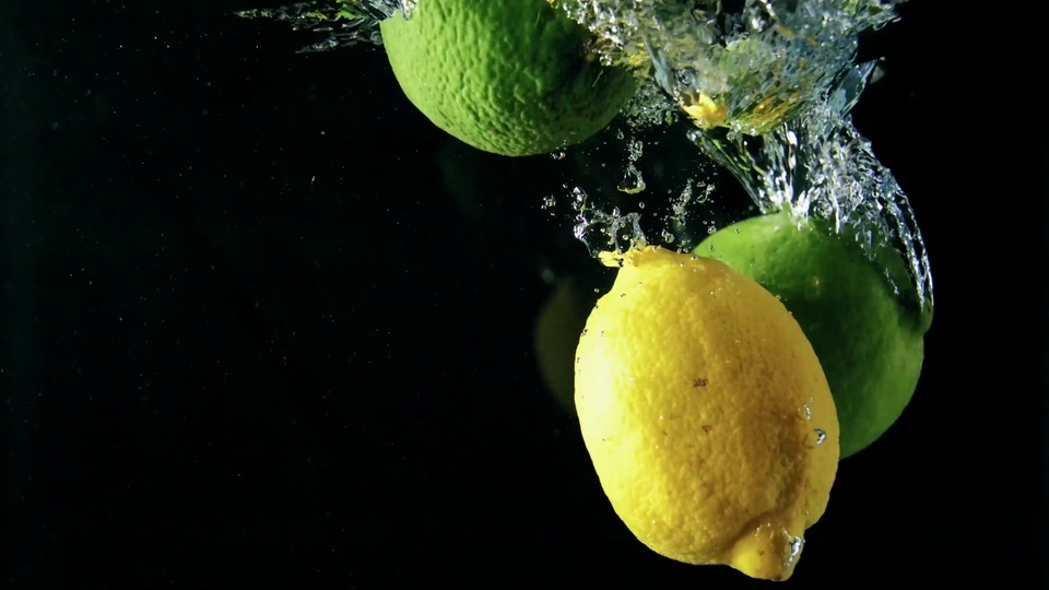 Fruta cayendo en la lente de agua